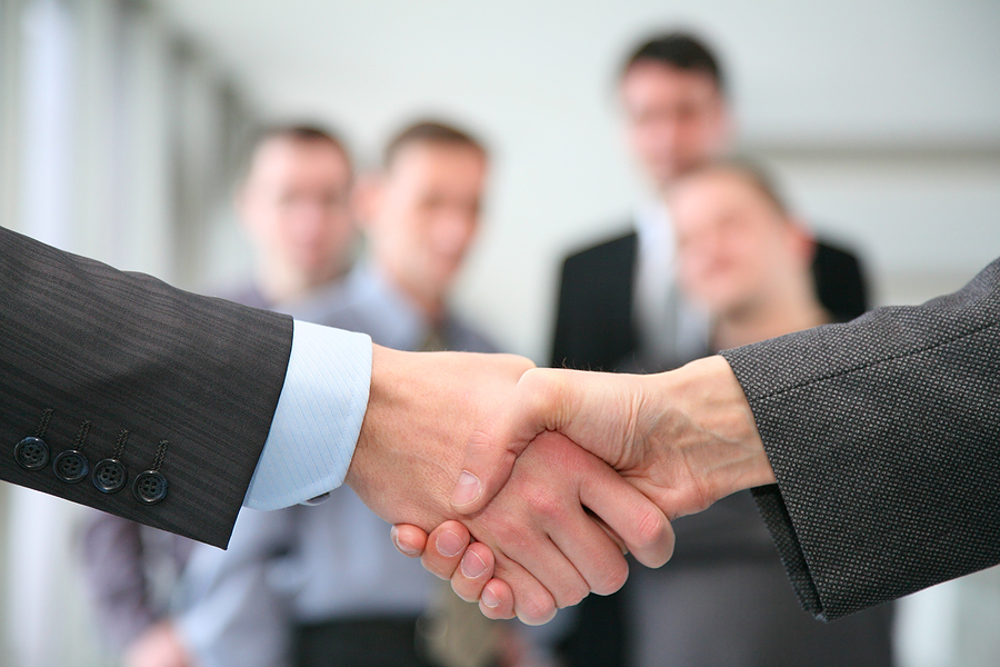 Corporate-Handshake-with-business-people-in-the-background1 Corporate-Handshake-with-business-people-in-the-background1